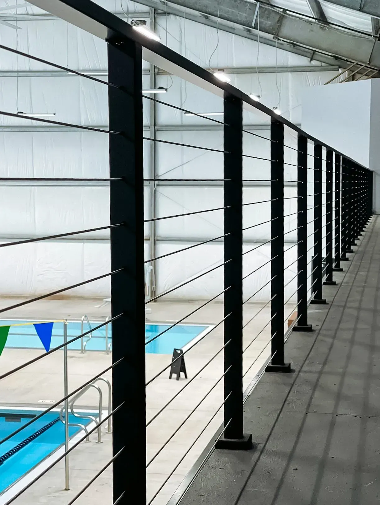 A fence surrounds a swimming pool in a building