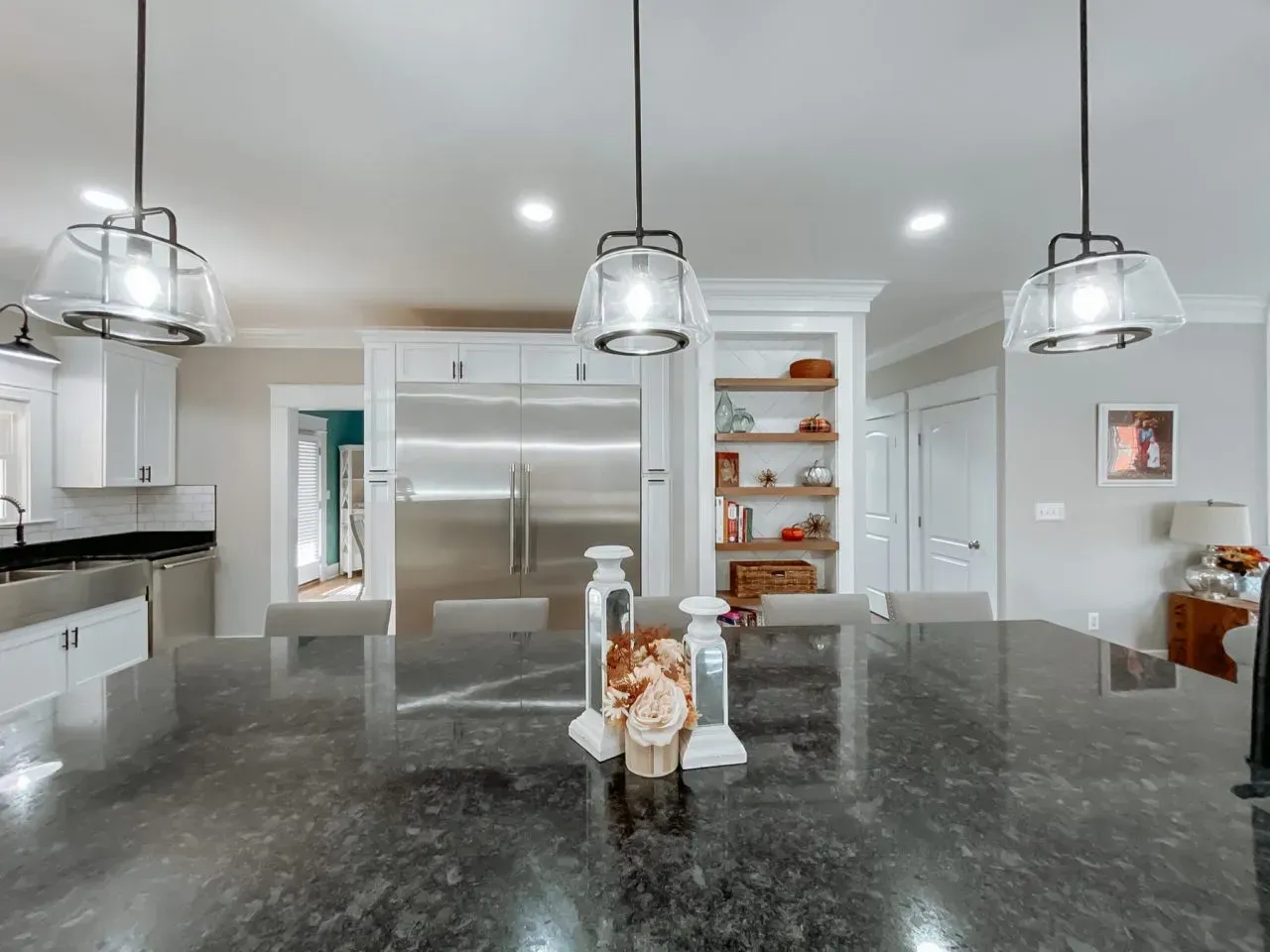 A kitchen with a large granite counter top and stainless steel appliances.