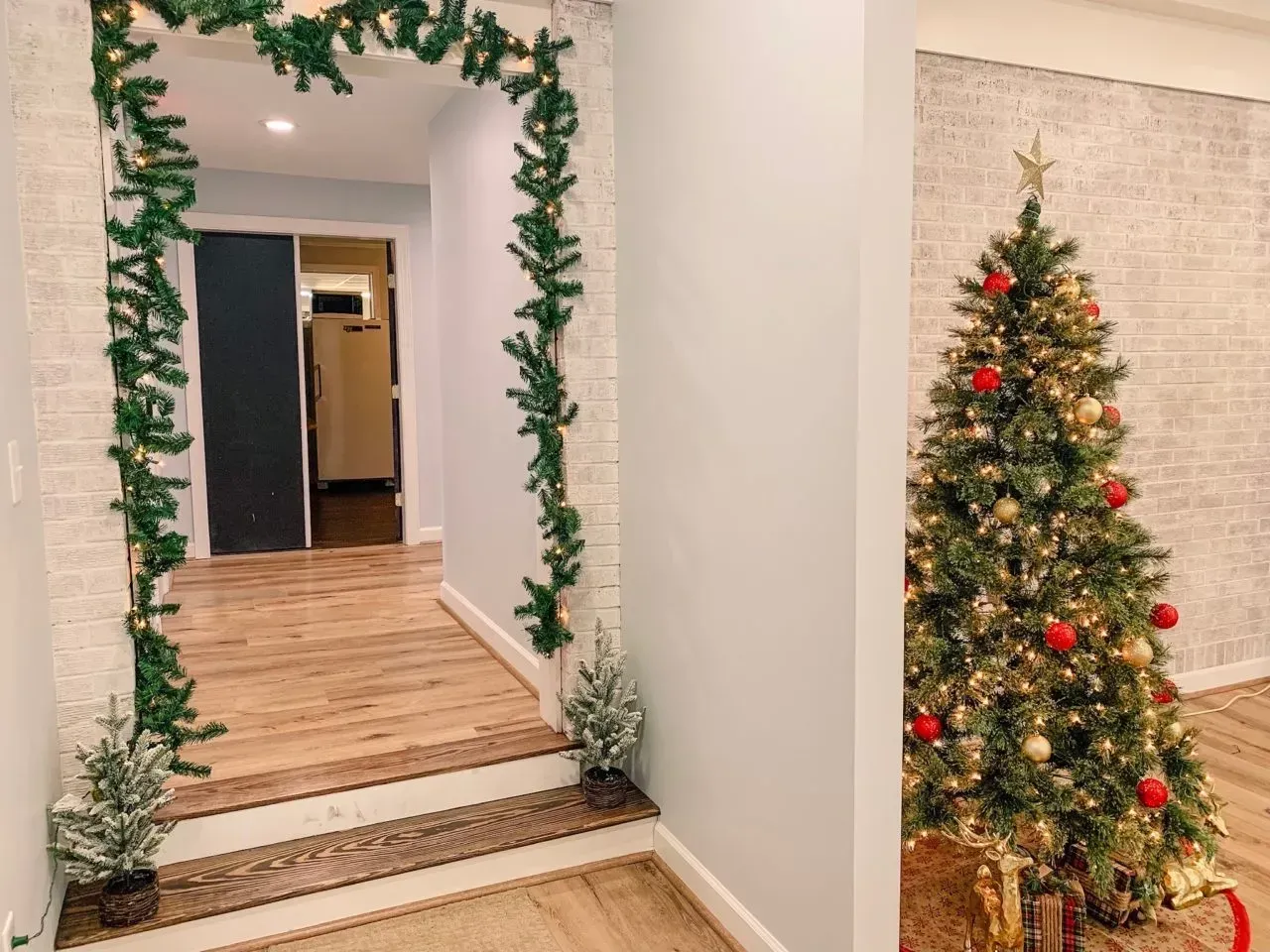 There is a christmas tree in the middle of the hallway.
