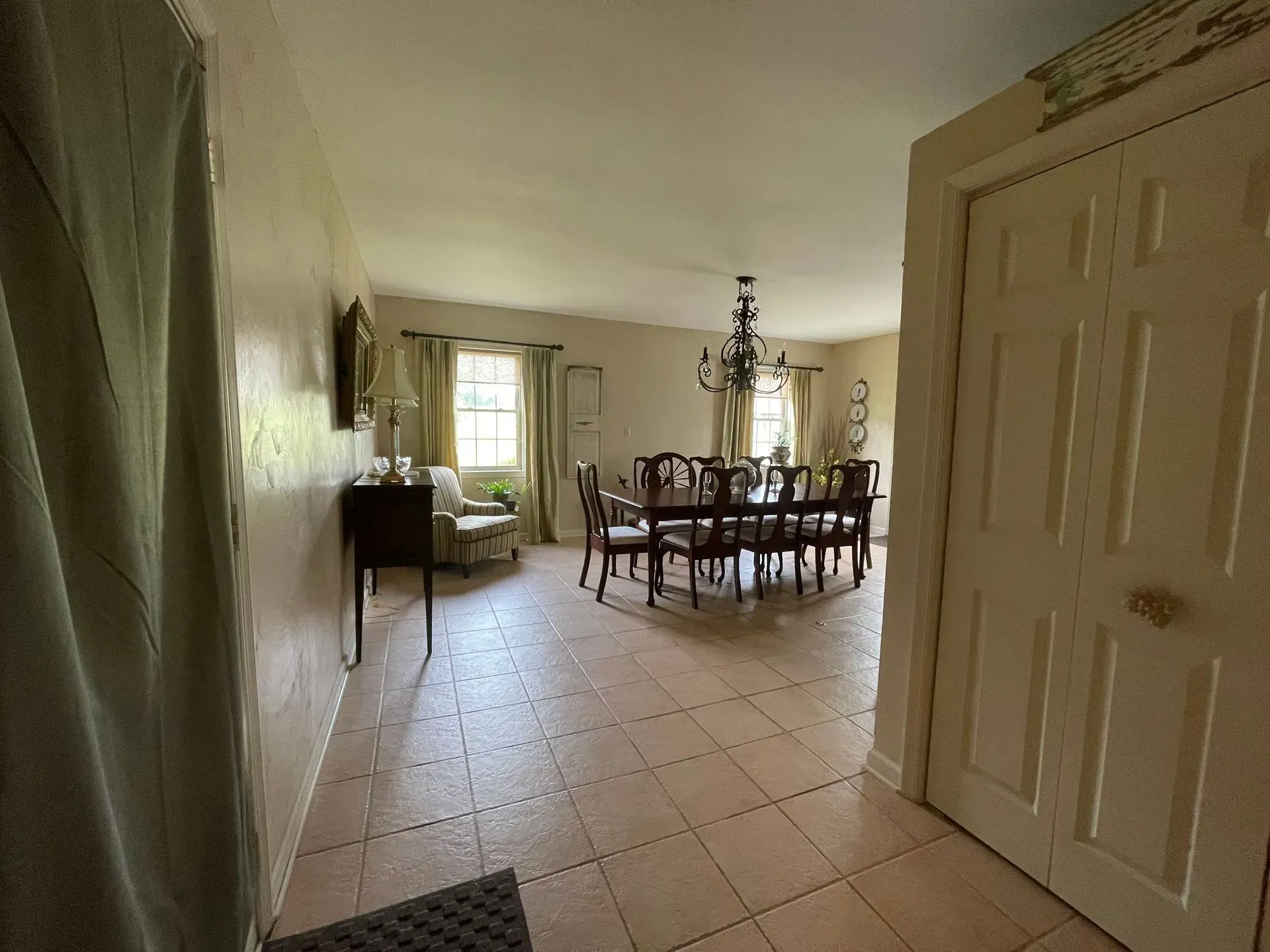 A hallway leading to a dining room with a table and chairs.