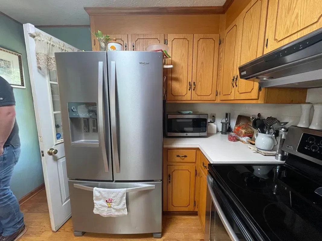 A kitchen with a stainless steel refrigerator , stove , and microwave.