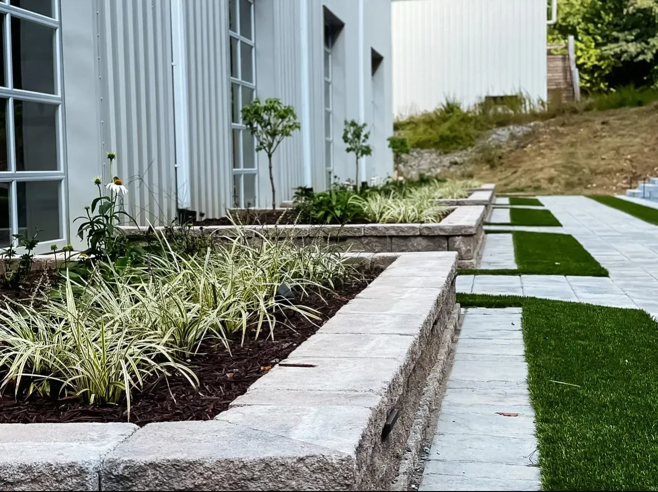 A row of planters in front of a white building