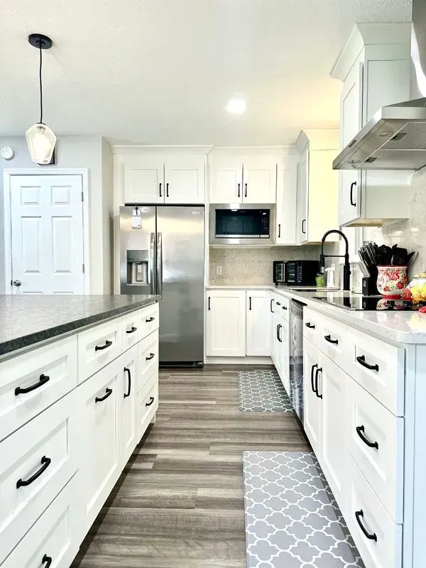 A kitchen with white cabinets and stainless steel appliances.