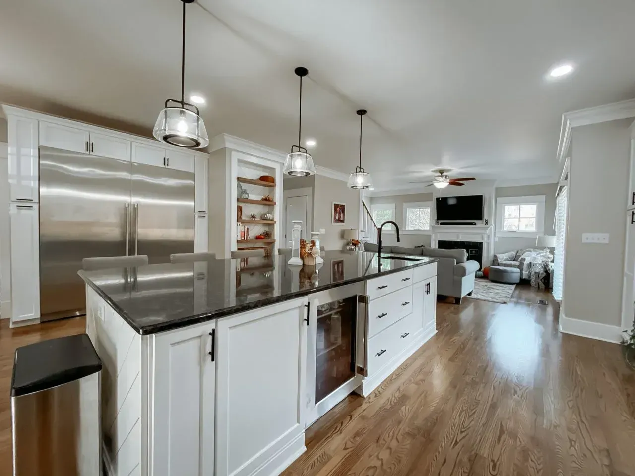 A kitchen with white cabinets and stainless steel appliances and a large island.