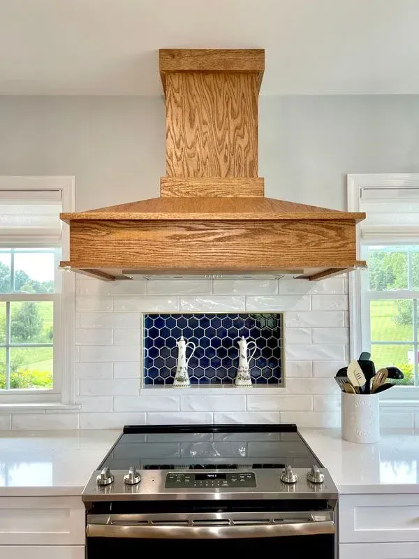 There is a wooden hood above the stove in the kitchen.