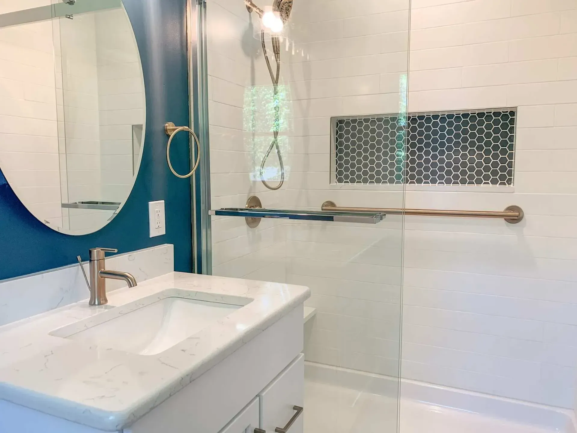 A bathroom with a sink , mirror and shower.