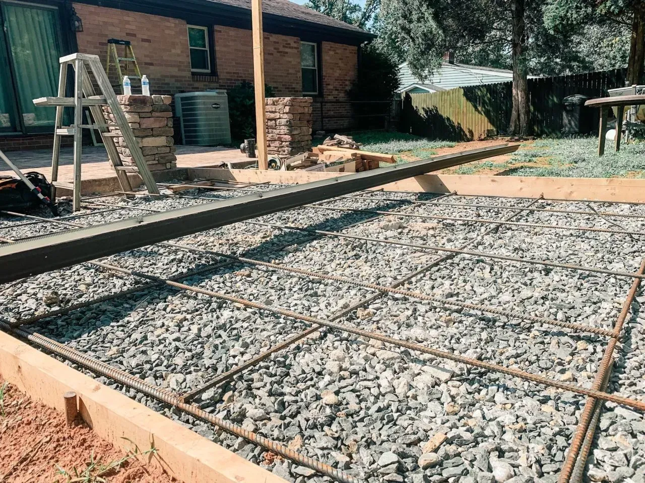 A concrete driveway is being built in a backyard.