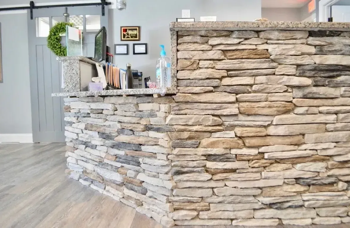 A stone wall is behind a counter in a room.