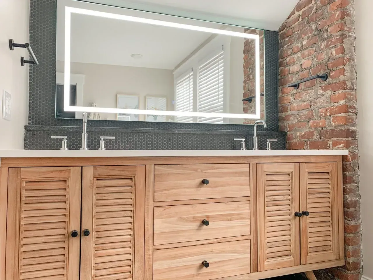 A bathroom with a wooden vanity and a large mirror.