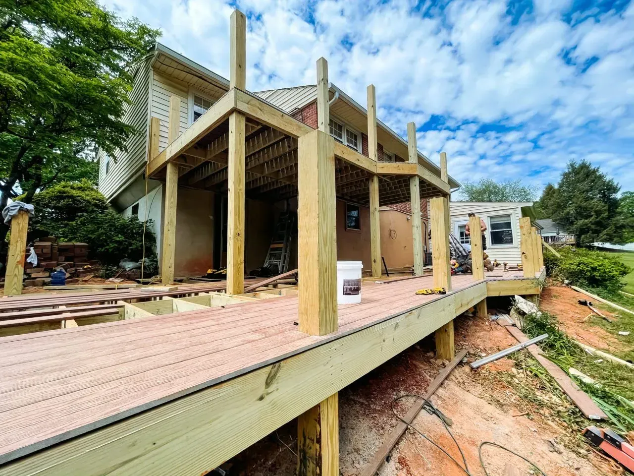 A wooden deck is being built on the side of a house.