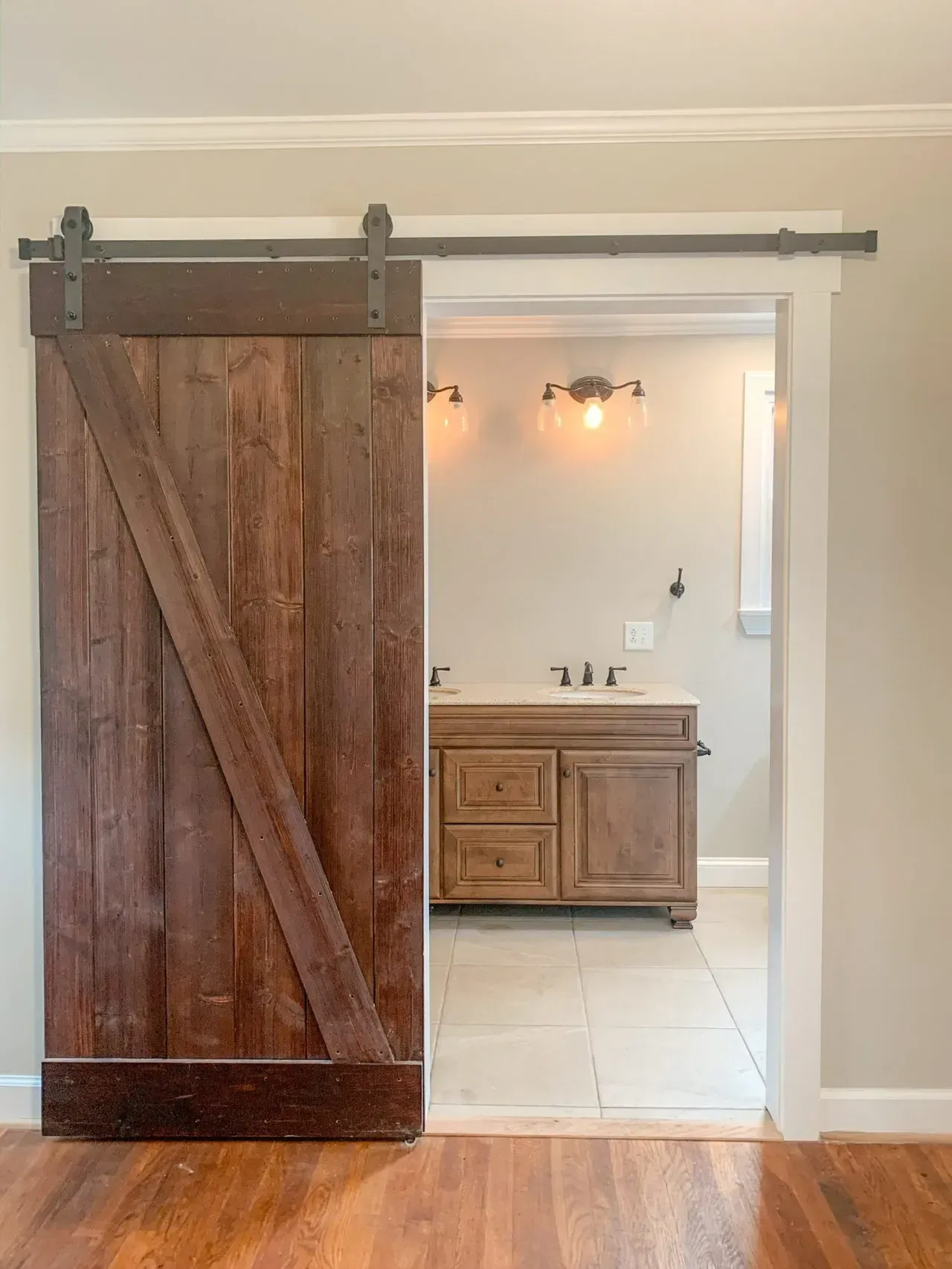 A bathroom with a sliding barn door leading to it.