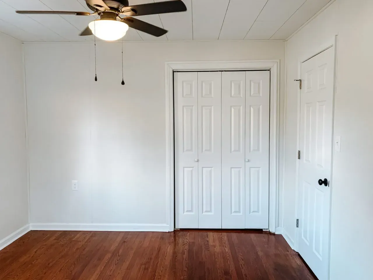 There is a ceiling fan in the corner of the room.