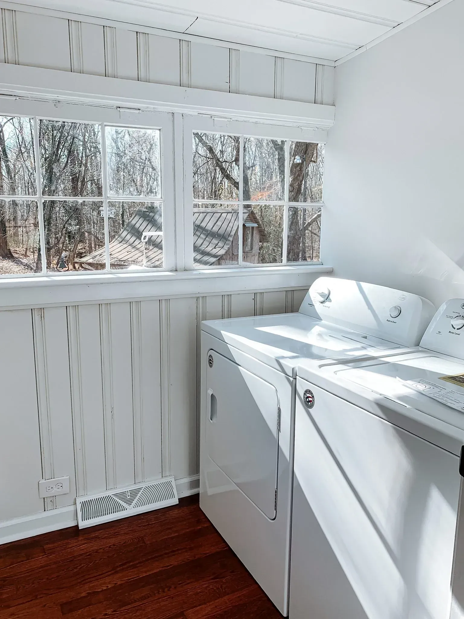 A laundry room with a washer and dryer and a window