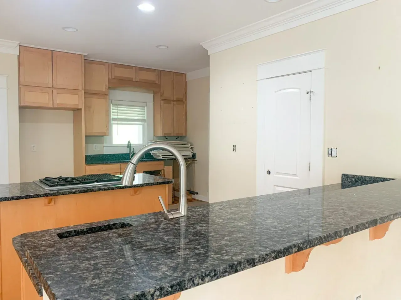 A kitchen with a granite counter top and a sink.