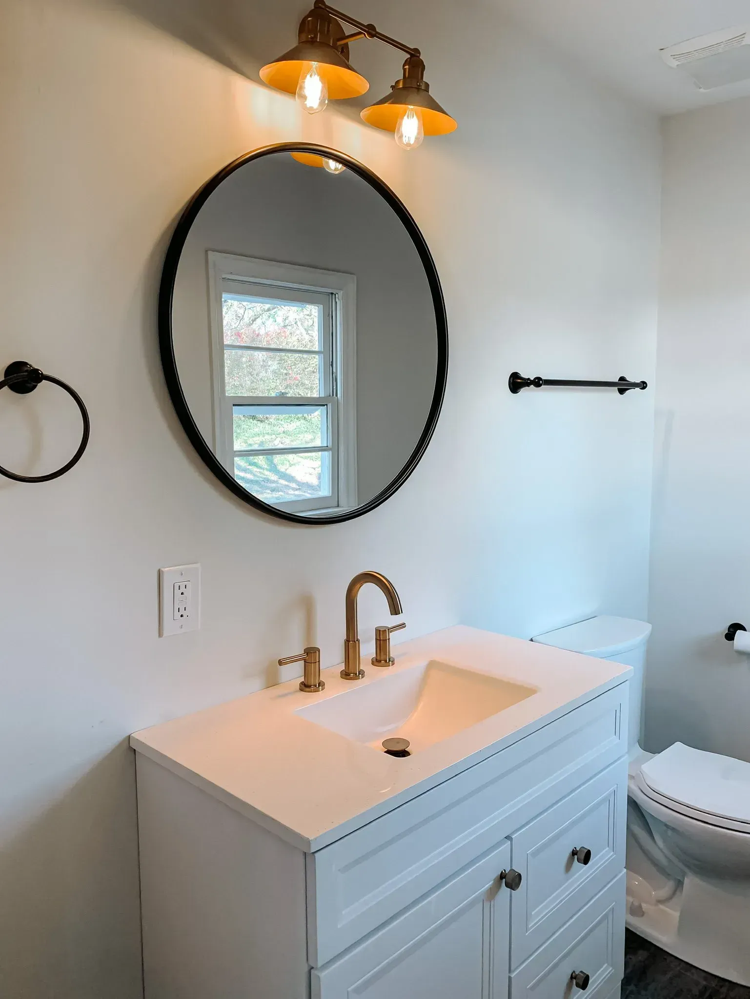 A bathroom with a sink a mirror and a toilet
