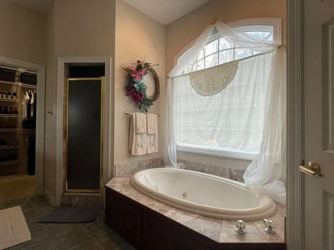 A bathroom with a large tub and a window.