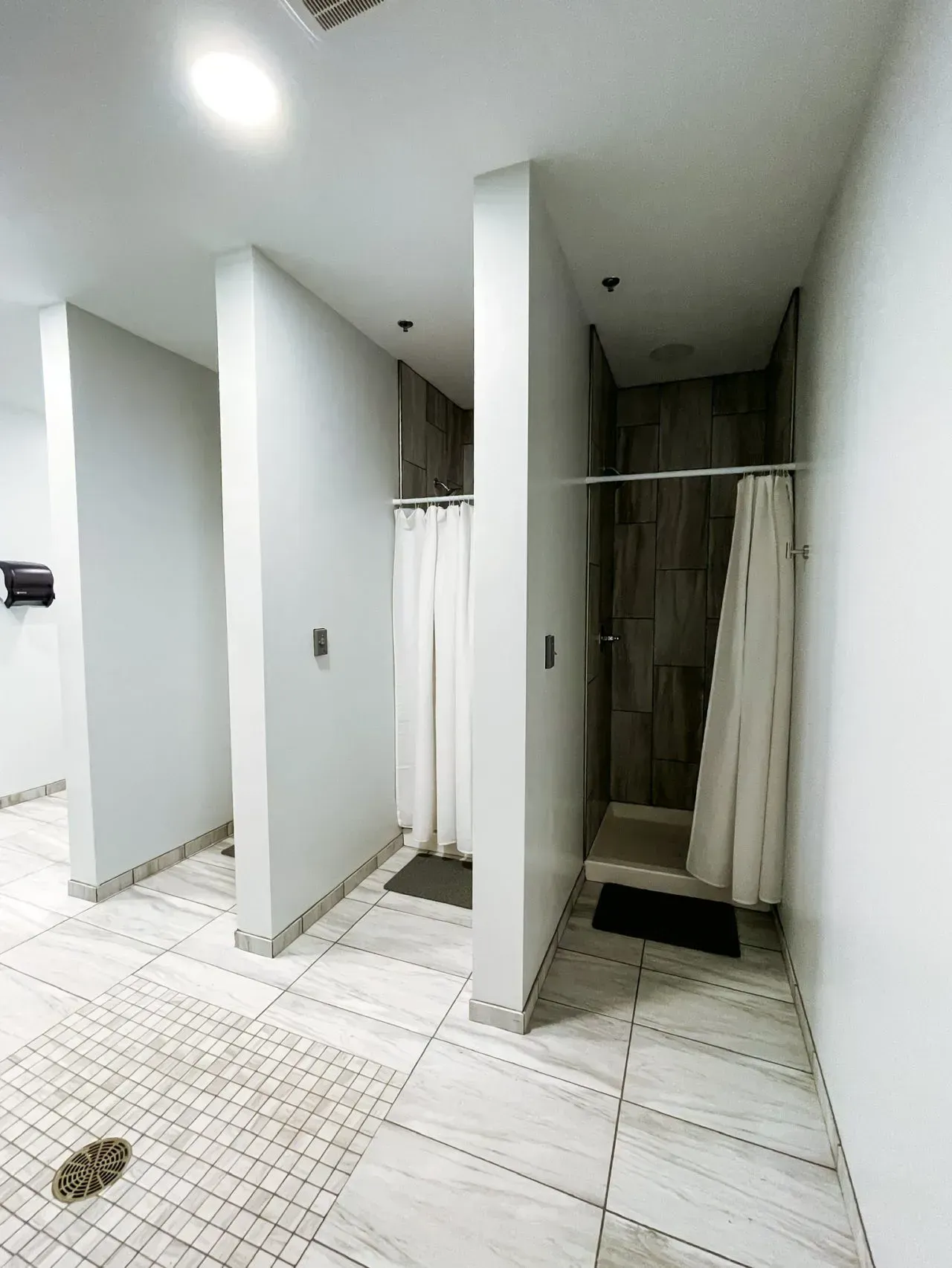 A bathroom with a shower curtain hanging from the ceiling