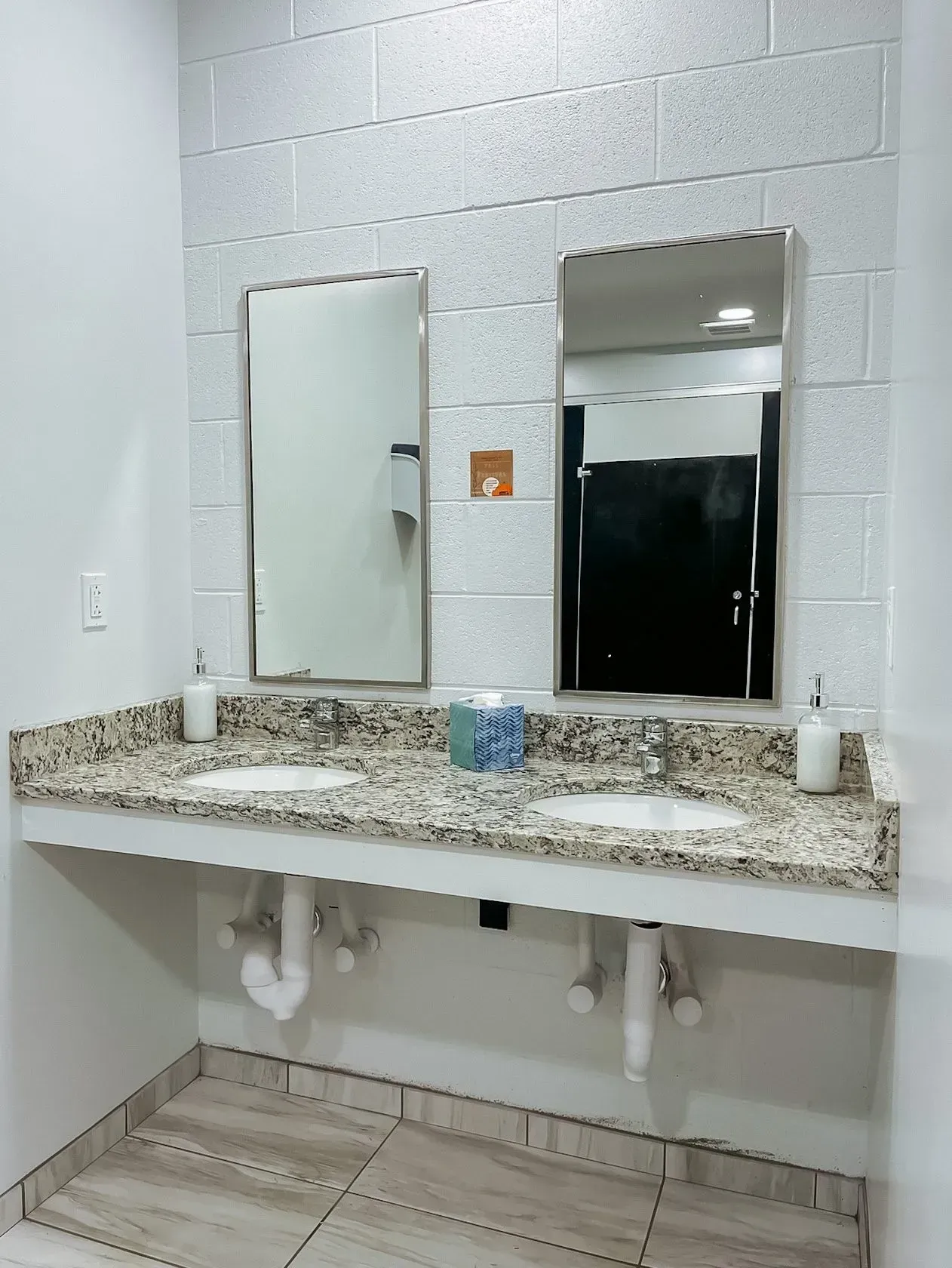 A bathroom with two sinks and two mirrors.
