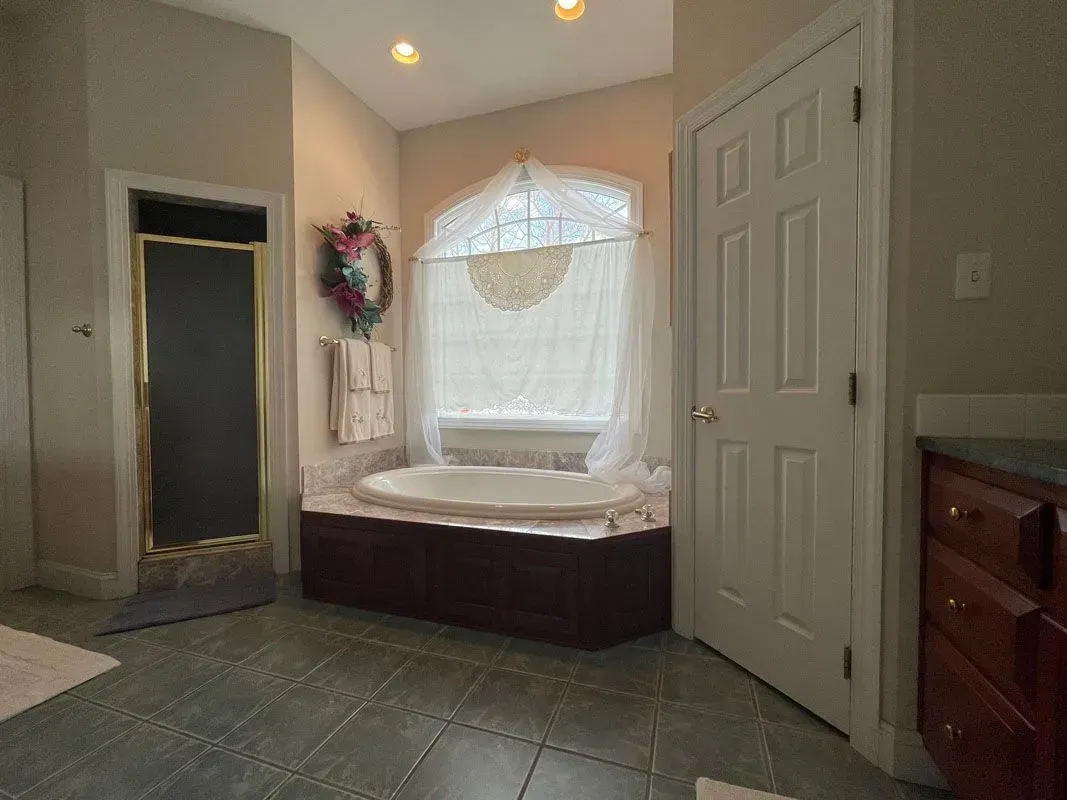 A bathroom with a large tub and a window.