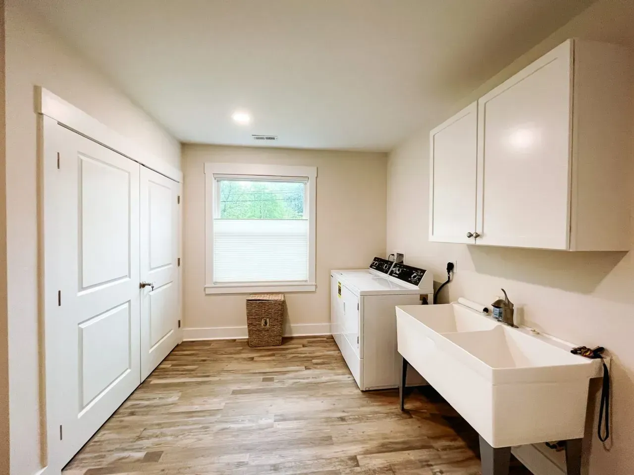 A laundry room with a washer and dryer and a sink.