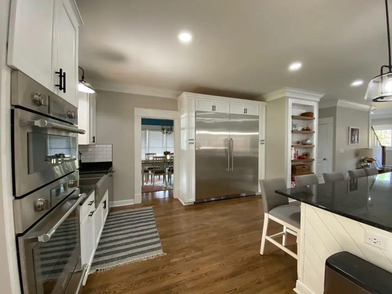 A kitchen with stainless steel appliances and a black counter top