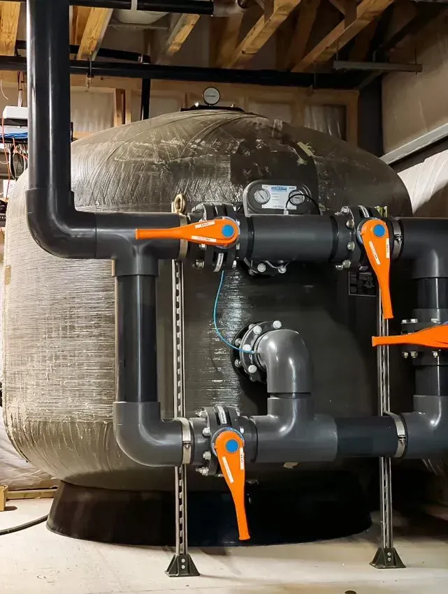 A large tank with lots of pipes and valves attached to it