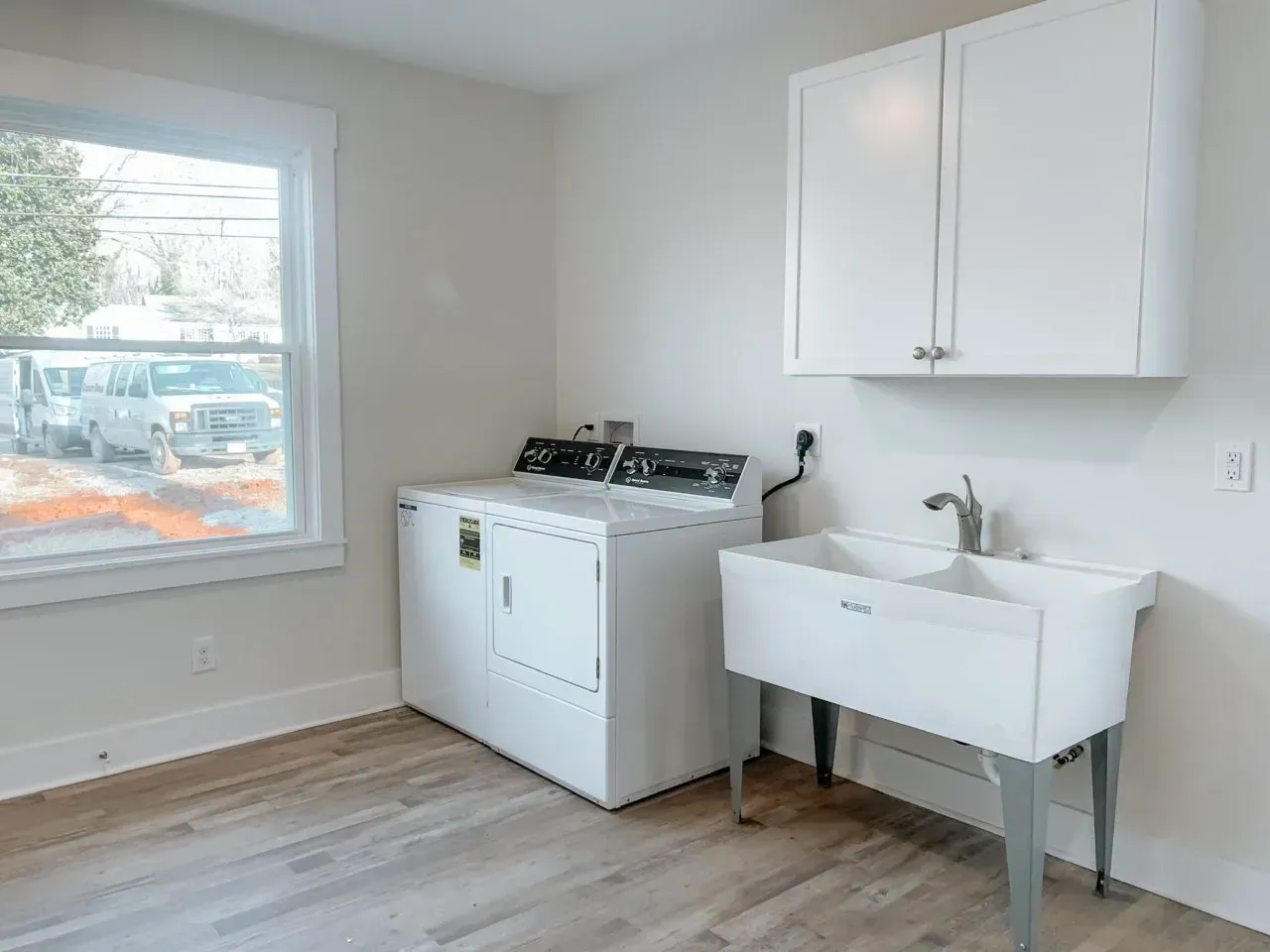 A laundry room with a washer and dryer and a sink.