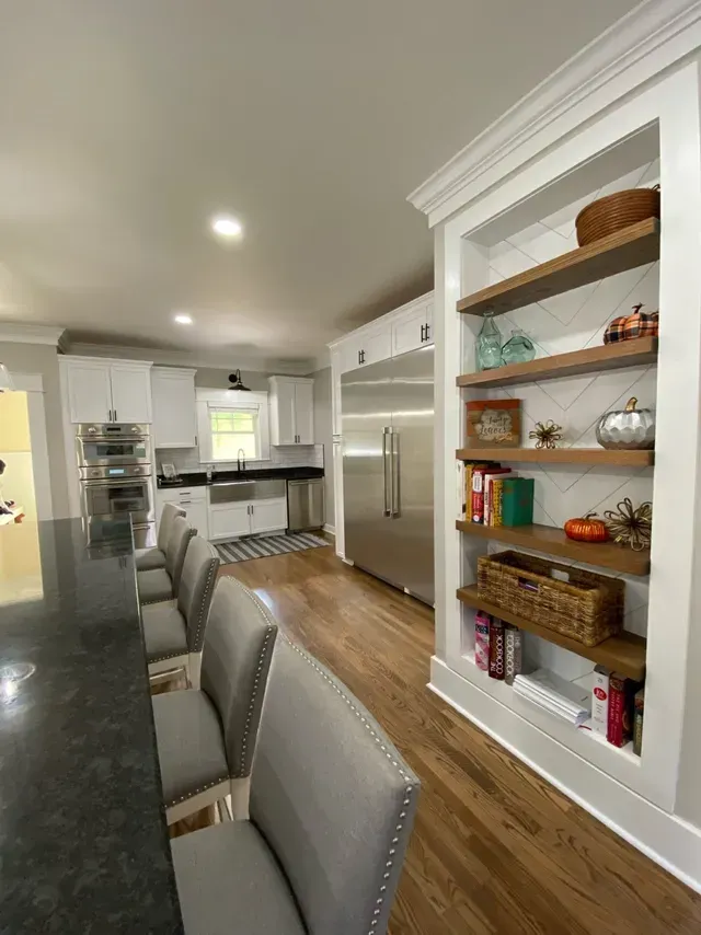 A kitchen with stainless steel appliances and wooden shelves
