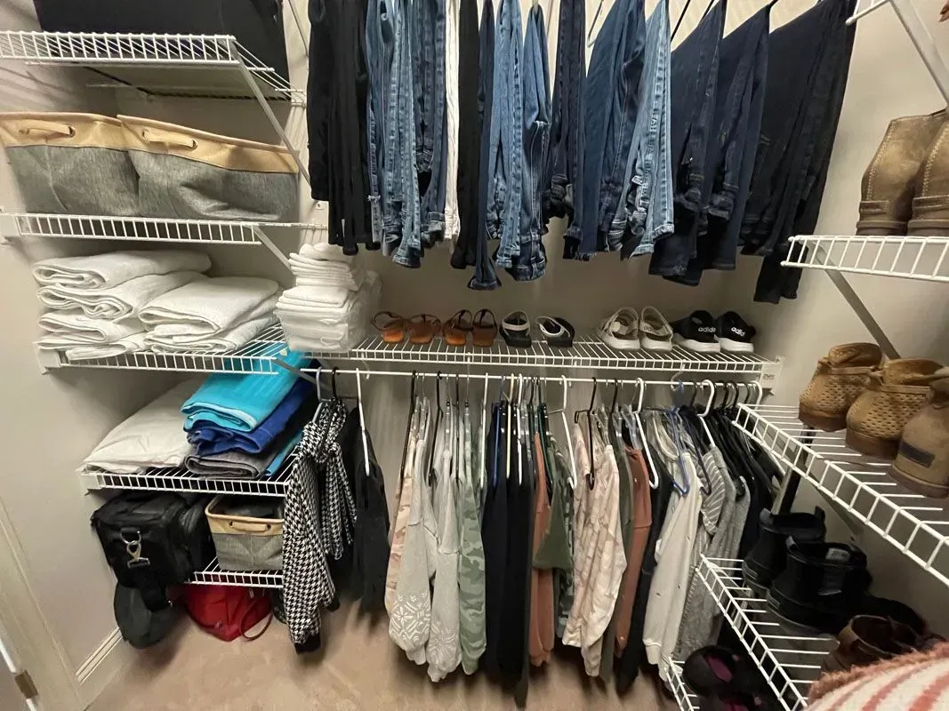 A closet filled with lots of clothes and shoes.