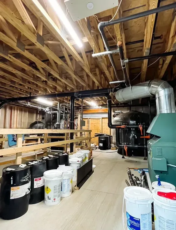 A room with a lot of buckets and pipes in it.