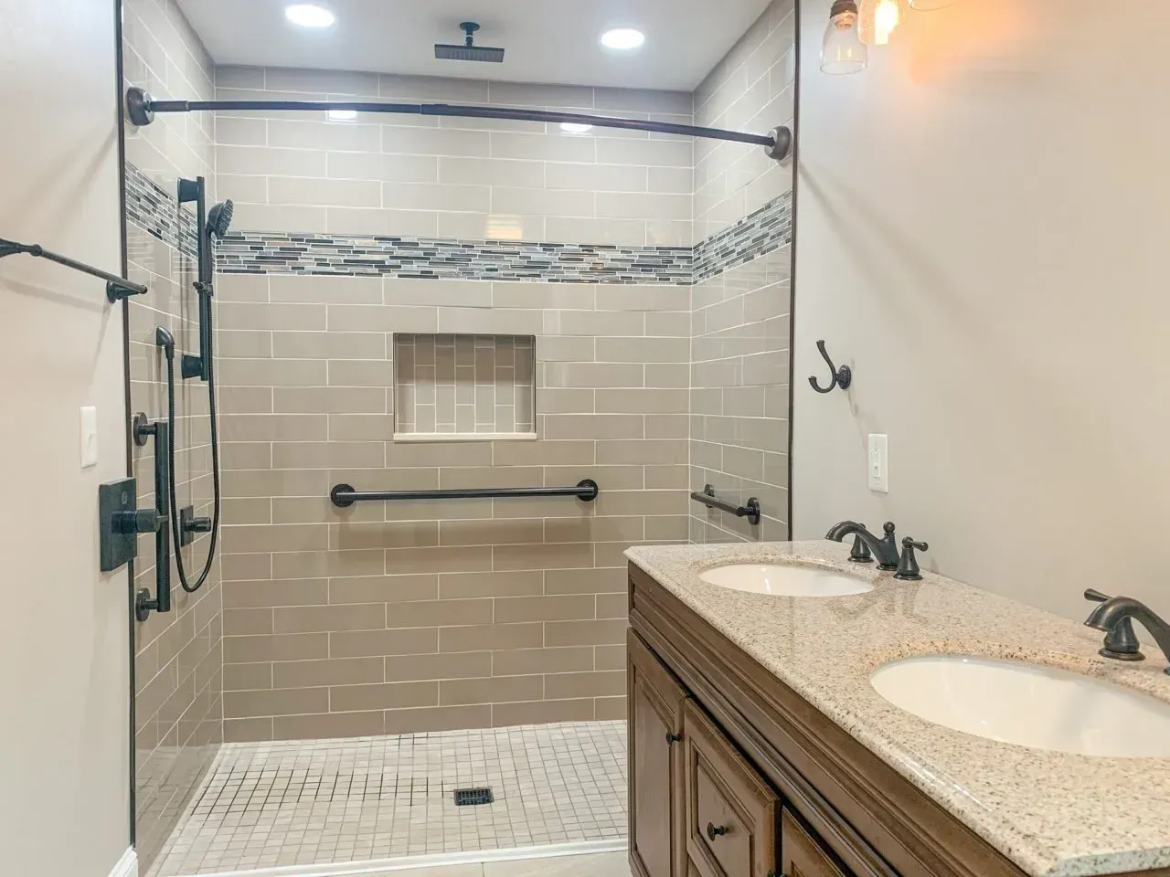 A bathroom with a walk in shower and two sinks.