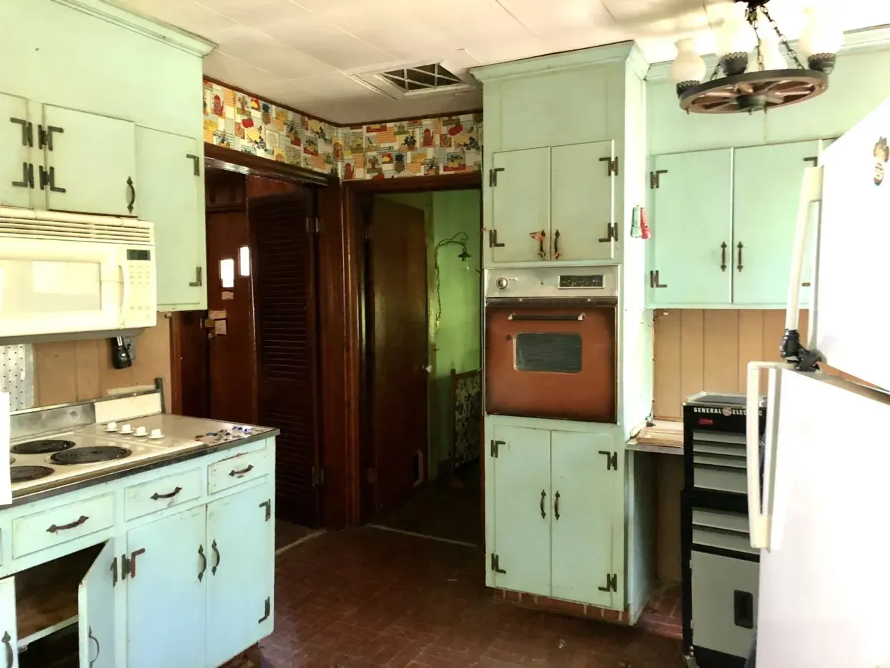 A kitchen with light blue cabinets and white appliances
