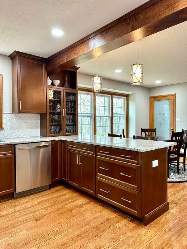A kitchen with wooden cabinets , stainless steel appliances , and a large island.