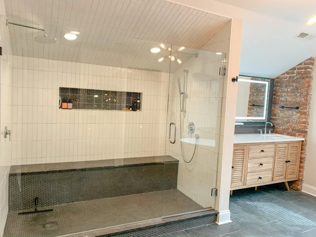 A bathroom with a walk in shower and a sink.