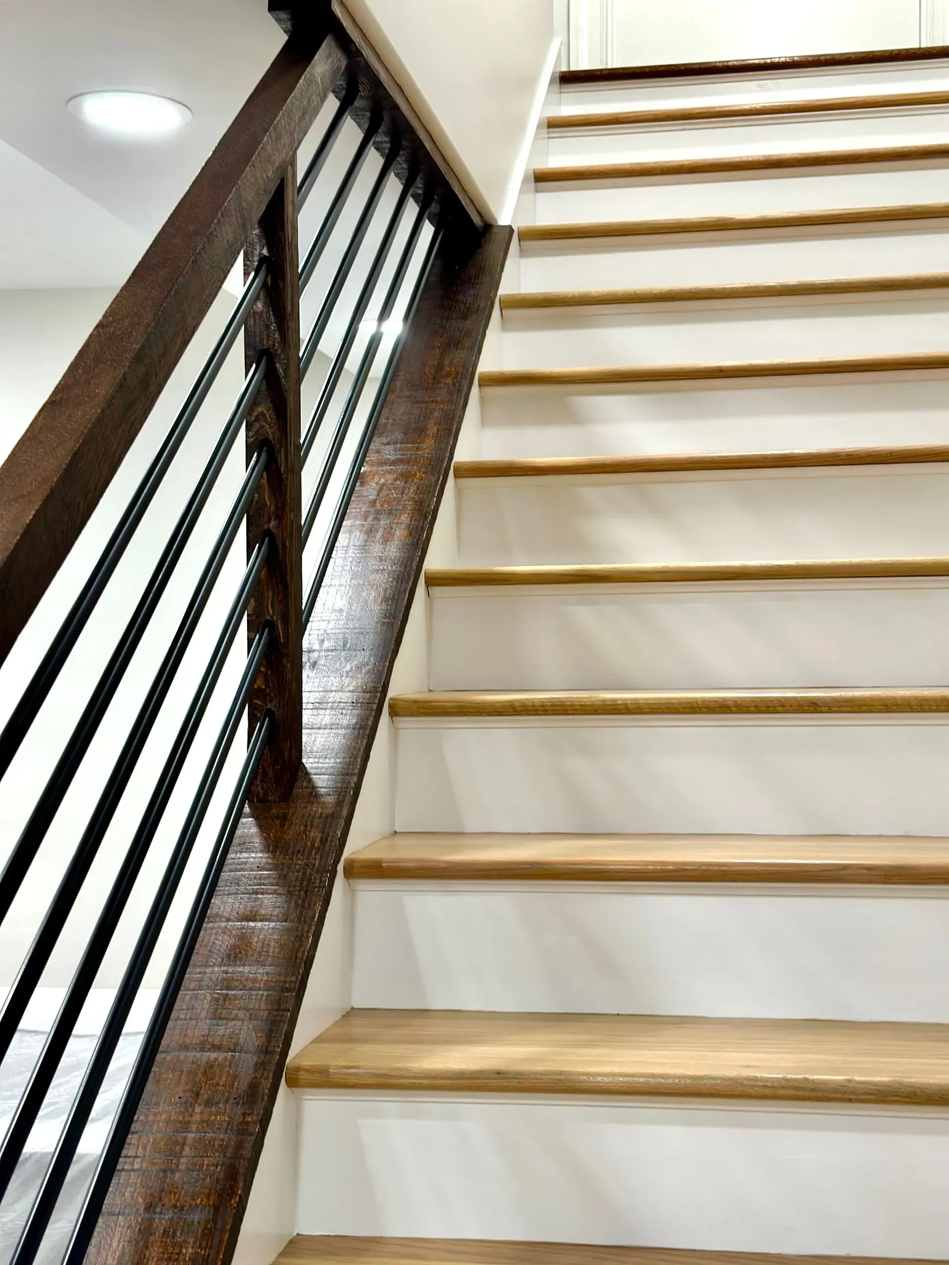 A staircase with a wooden railing and white steps