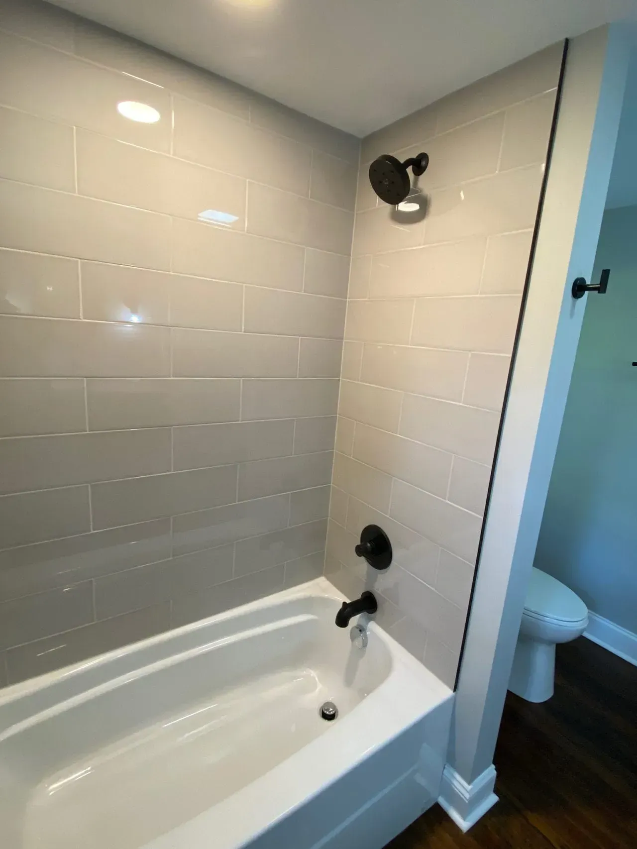 A bathroom with a bathtub , toilet and shower.