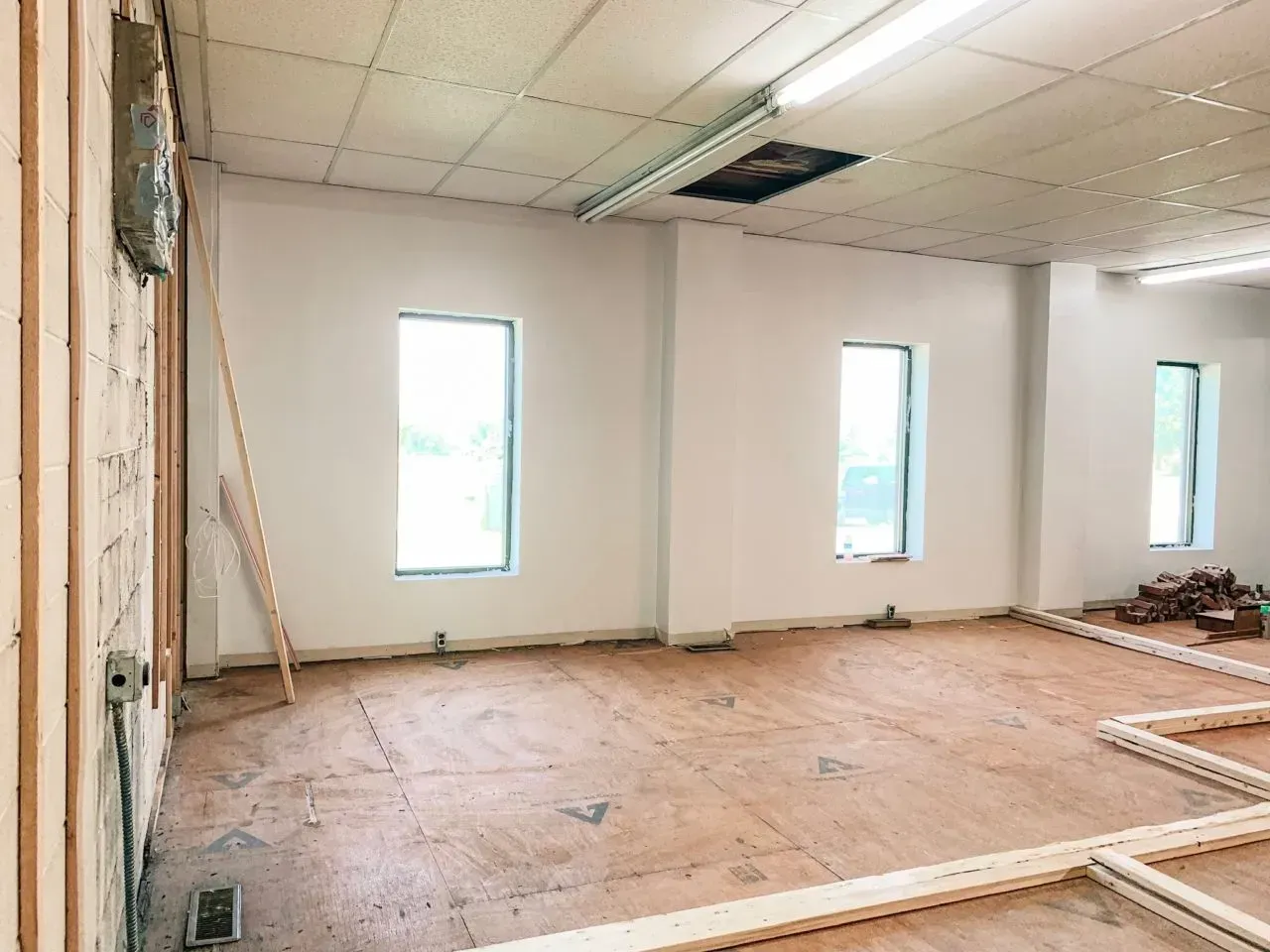 An empty room with a wooden floor and white walls.