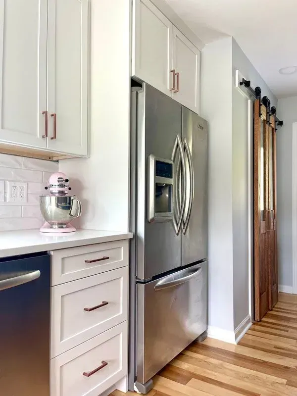 A kitchen with stainless steel appliances and white cabinets.