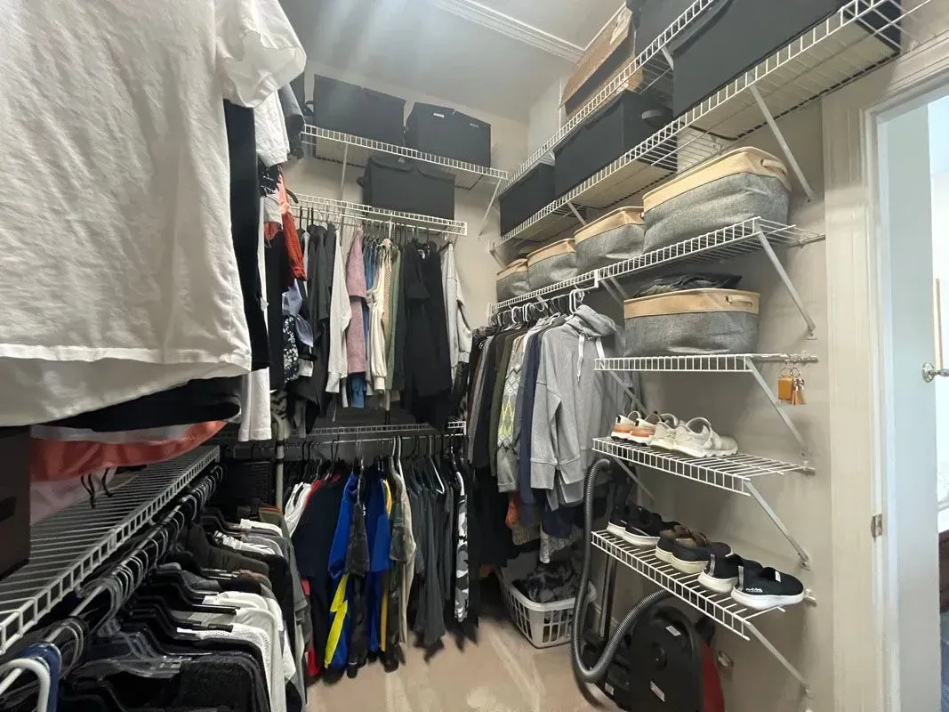 A walk in closet filled with clothes and shoes.