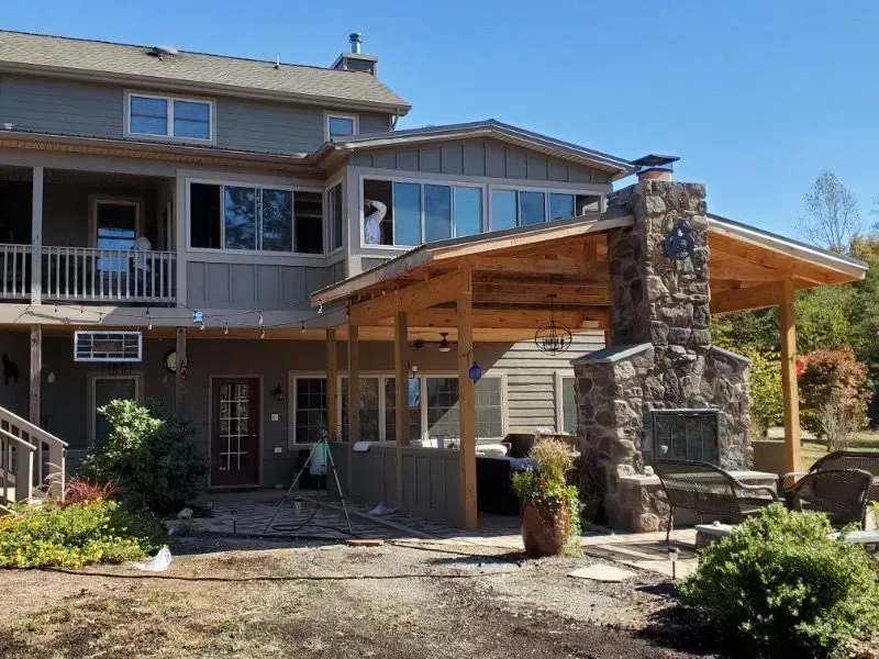 A large house with a stone fireplace and a covered porch.