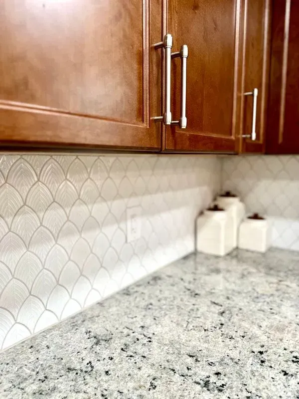 A kitchen with granite counter tops and wooden cabinets.