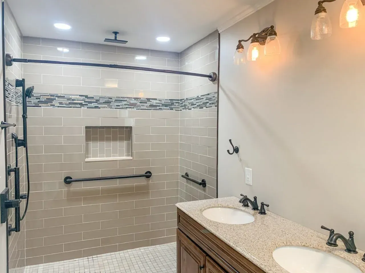 A bathroom with a walk in shower and two sinks.