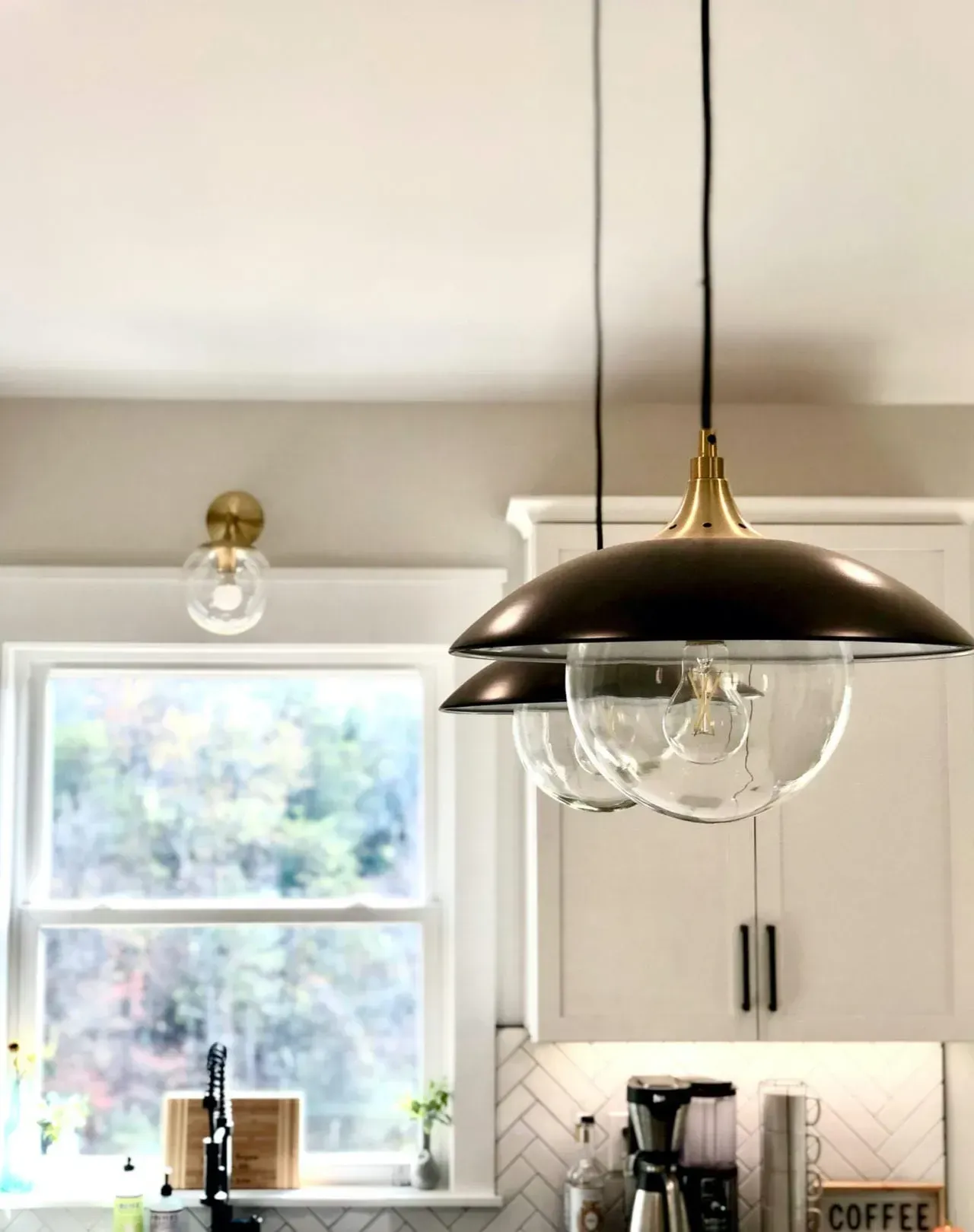 A kitchen with two pendant lights hanging from the ceiling