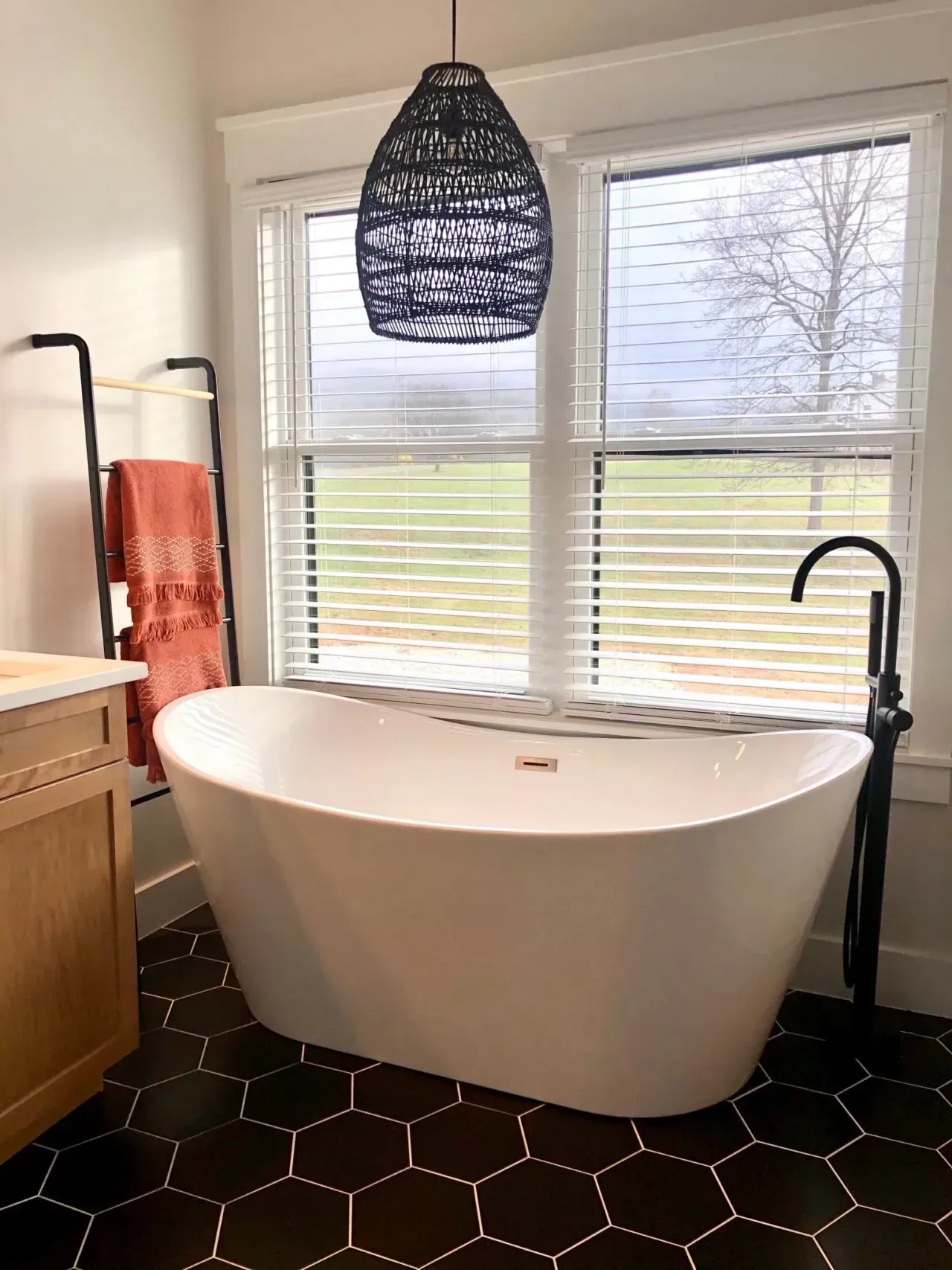 A bathroom with a bathtub , sink , and window.