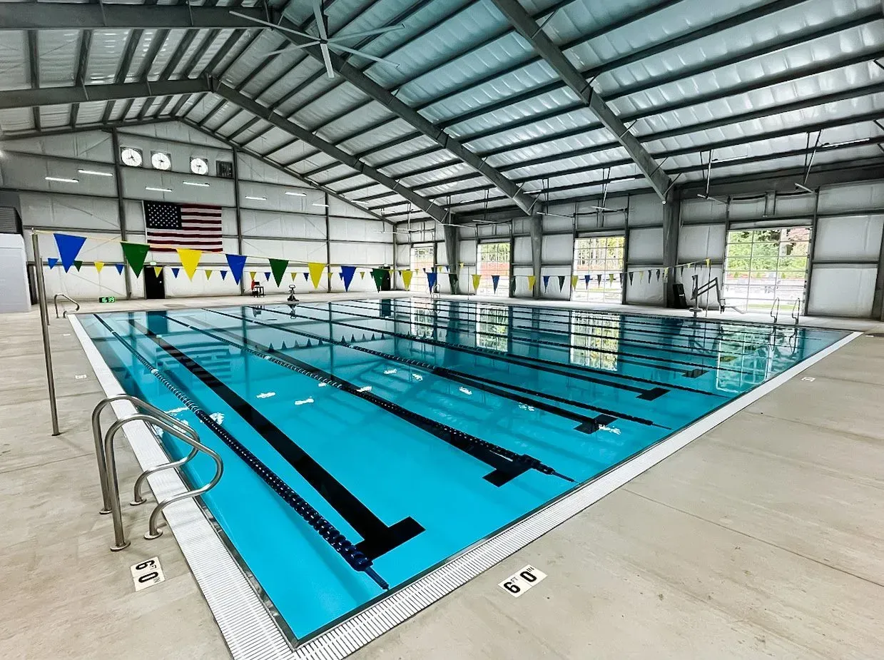 A large indoor swimming pool with a flag on the wall.