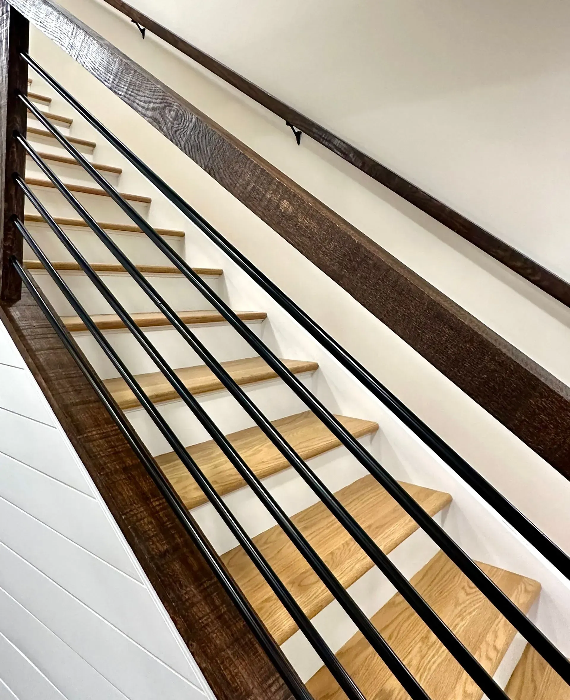 A staircase with a black railing and wooden steps