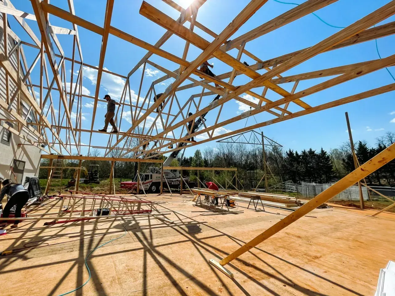 A group of construction workers are working on a large wooden structure.