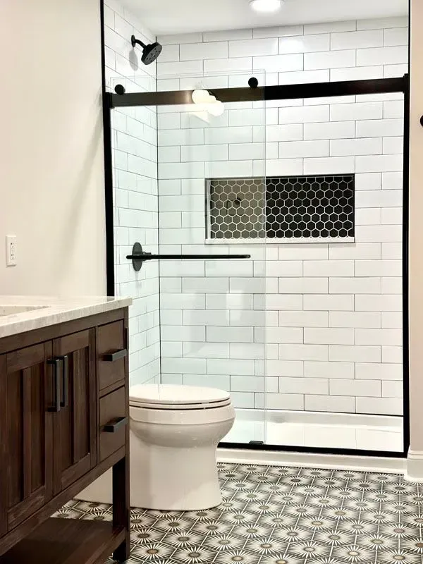 A bathroom with a toilet , sink , and shower.