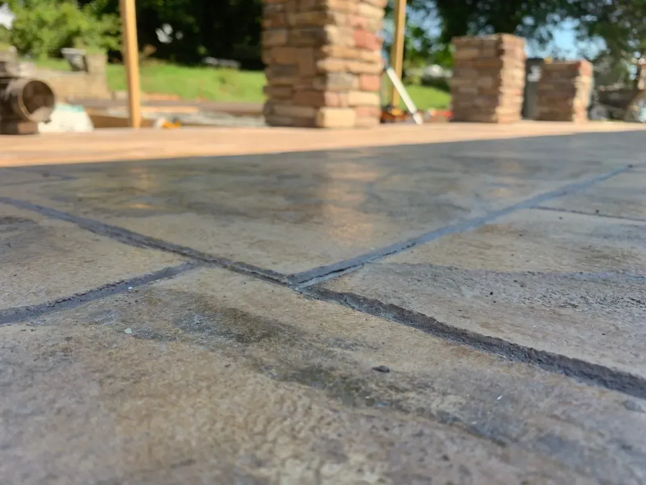 A close up of a tiled floor with a brick wall in the background.