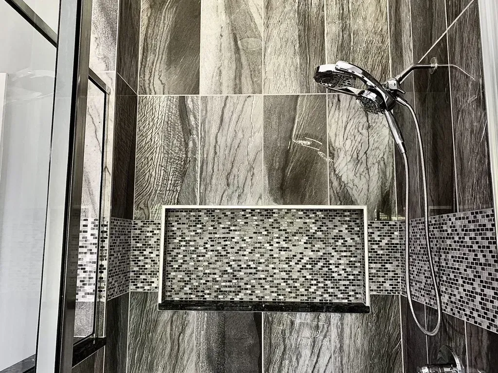 A black and white photo of a bathroom with a shower head.